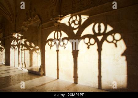 Ombres d'arcs gothiques complexes coulées sur un mur de pierre à Mosteiro dos Jeronimos, Lisbonne Banque D'Images