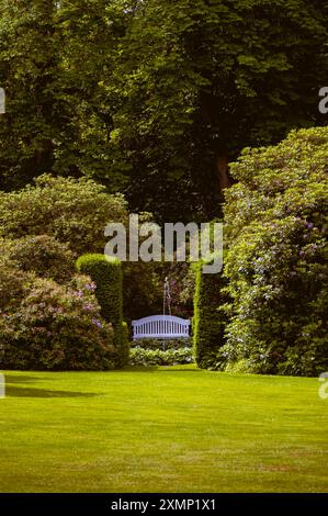 Un banc blanc devant une fontaine dans les jardins du château de Krapperup à Skåne Suède Banque D'Images