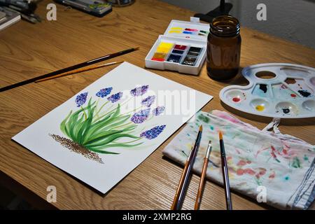 Un espace de travail d'artiste accueillant avec une peinture à l'aquarelle vibrante de fleurs en cours. Illustration, créativité, techniques artistiques, artistiques. Banque D'Images
