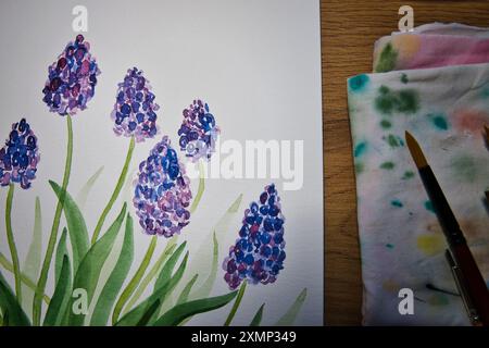 Un espace de travail d'artiste accueillant avec une peinture à l'aquarelle vibrante de fleurs en cours. Illustration, créativité, techniques artistiques, artistiques. Banque D'Images