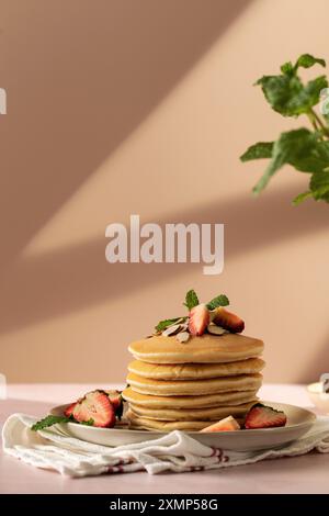 Profitez d'un merveilleux petit déjeuner avec des crêpes, des fraises et du miel sous la lumière chaude du soleil Banque D'Images