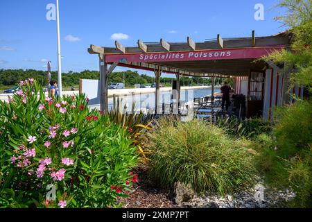 Audenge, Baie d'Arcachon, France. Un restaurant de spécialités de poisson est situé au bord de la plus grande piscine d'eau de mer en plein air d'Europe. Banque D'Images