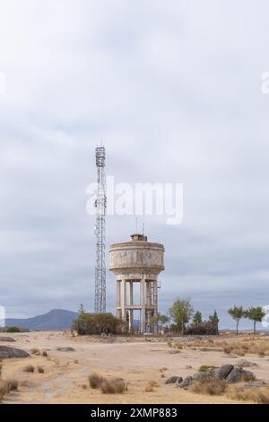 Réservoir d'eau et tour de télécommunications sur la route de campagne, le ciel est nuageux et la sécheresse peut être vu dans le paysage. Banque D'Images