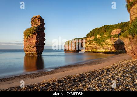 Un empilement de grès dans la baie de Ladram près de Sidmouth dans le sud-est du Devon, capturé au lever du soleil en juillet. Banque D'Images