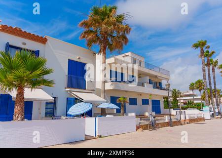 Tarragone, Espagne - 14 juillet 2024 : charmantes maisons aux murs blancs avec volets bleus bordant la promenade du bord de mer Banque D'Images