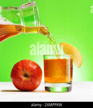 Jus de pomme versé de la verseuse dans un verre Banque D'Images