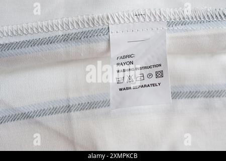 Blanc entretien du linge instructions de lavage étiquette des vêtements sur la chemise en rayonne Banque D'Images