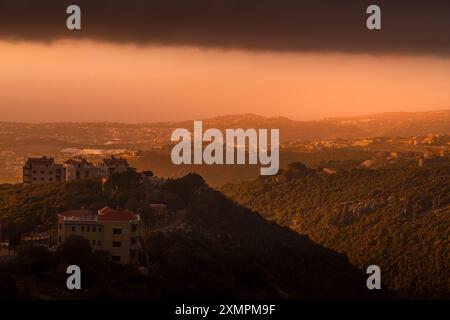 Le beau coucher de soleil sur la côte du Liban, à la mer Méditerranée, avec des couleurs vives, panorama de la ville et paysage du moyen-Orient. Banque D'Images