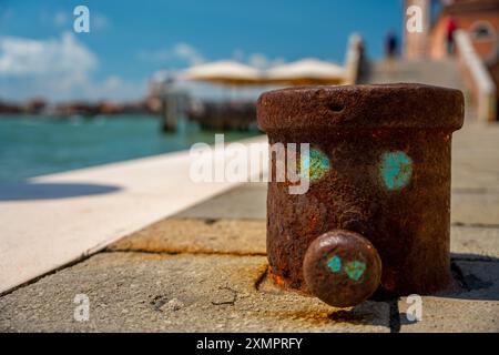 Venise, Italie - 05 juin 2024 : amarrage rouillé avec un visage mignon dessus. Banque D'Images