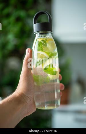 Eau à la menthe, thym, citron vert pour boire dehors par temps chaud, bouteille avec de l'eau de menthe et de citron Banque D'Images