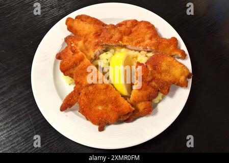 Backhendl mit Kartoffelsalat. Backhendl oder Wiener Backhendl - auch Backhuhn, Backhähnchen, Französisch poulet frit a la viennoise, ist seit dem 18. Jahrhundert eine Spezialität der Wiener Küche. Es besteht aus vorbereiteten und gewürzten Teilstücken vom Huhn, die paniert und frittiert oder ausgebacken werden *** poulet cuit avec salade de pommes de terre poulet cuit ou poulet frit viennois, également connu sous le nom de poulet frit, frit de poulet français à la viennoise, a été une spécialité de la cuisine viennoise depuis le 18ème siècle, il se compose de morceaux préparés et assaisonnés de poulet qui sont panés et deep-fr Banque D'Images