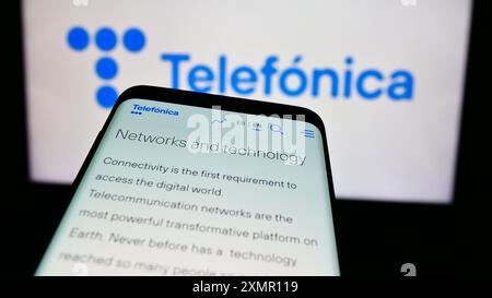 Téléphone portable avec le site de la société espagnole de télécommunications Telefonica S.A. devant le logo de l'entreprise. Concentrez-vous sur le coin supérieur gauche de l'écran du téléphone. Banque D'Images