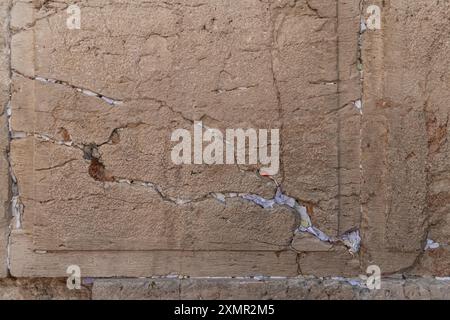 Notes de papier avec bénédictions et prières à l'intérieur des fissures du mur occidental. Le mur occidental, également connu sous le nom de mur des lamentations à l'Ouest et mur d'Al Buraq dans l'Islam, est une destination de pèlerinage pour les croyants juifs. Situé dans la vieille ville de Jérusalem, il fait partie du mur de soutènement du Mont du Temple. Une cloison métallique divise la zone en deux : les hommes à gauche et les femmes à droite. Tout au long de la journée, les croyants juifs visitent le site pour prier, lire les livres sacrés de la Torah et laisser une note de papier à l’intérieur des fissures du mur. Toute la zone est surveillée par des soldats israéliens. (Photo de Matteo Placucci Banque D'Images