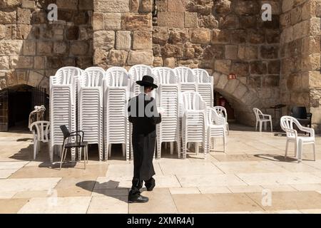 26 juillet 2024, Jérusalem, Israël : adorateur juif vu du côté des hommes du mur Occidental. Le mur occidental, également connu sous le nom de mur des lamentations à l'Ouest et mur d'Al Buraq dans l'Islam, est une destination de pèlerinage pour les croyants juifs. Situé dans la vieille ville de Jérusalem, il fait partie du mur de soutènement du Mont du Temple. Une cloison métallique divise la zone en deux : les hommes à gauche et les femmes à droite. Tout au long de la journée, les croyants juifs visitent le site pour prier, lire les livres sacrés de la Torah et laisser une note de papier à l'intérieur des fissures du mur. Toute la zone est surveillée par des soldats israéliens. Banque D'Images