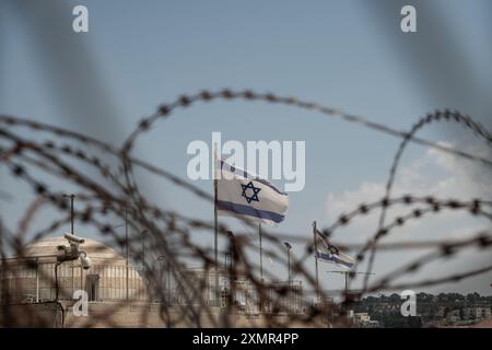 26 juillet 2024, Jérusalem, Israël : drapeaux israéliens vus à travers un fil de rasoir sur le toit des logements de la vieille ville. Jérusalem est la capitale d'Israël, elle est considérée comme l'une des plus anciennes villes du monde, et extrêmement importante pour les fidèles juifs, chrétiens et musulmans. Toutes ces religions se sont battues pour cette ville et essaient maintenant de coexister. Le gouvernement israélien en a le plein contrôle. (Crédit image : © Matteo Placucci/SOPA images via ZUMA Press Wire) USAGE ÉDITORIAL SEULEMENT! Non destiné à UN USAGE commercial ! Banque D'Images