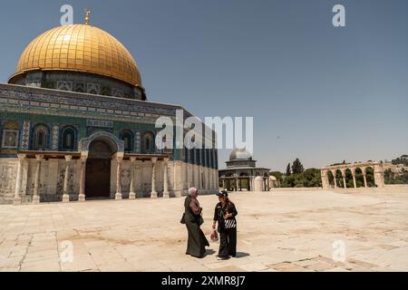 Jérusalem, Israël. 24 juillet 2024. Un adorateur musulman, et un touriste bavardant devant le Dôme du Rocher. L'enceinte de la mosquée Al Aqsa, également connue sous le nom de Haram al Sharif ou esplanade sainte de Jérusalem ou Temple Mont, est un lieu Saint dans le christianisme, le judaïsme et l'islam. Le complexe est composé de la mosquée Al Aqsa et du Dôme du Rocher. Le touriste peut visiter la région seulement quelques heures par jour et l'entrée aux deux bâtiments saints est autorisée uniquement aux croyants musulmans. Toute la zone est surveillée par des soldats israéliens. Crédit : SOPA images Limited/Alamy Live News Banque D'Images