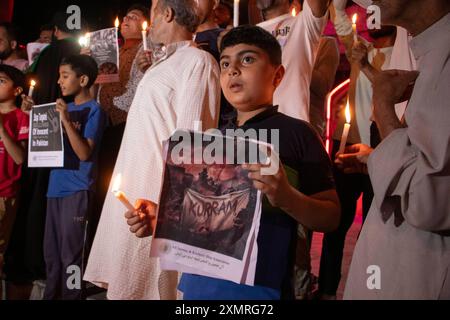 Srinagar, Jammu-et-Cachemire, Inde. 29 juillet 2024. Un garçon musulman chiite cachemiri tient une bougie et une pancarte lors d'une manifestation contre la violence sectaire visant les musulmans chiites pachtoun à Parachinar, situé dans le district de Kurram, dans la province pakistanaise de Khyber Pakhtunkhwa. Plus de 400 musulmans chiites ont été tués dans les violences sectaires chiites-sunnites qui se poursuivent à Parachinar. Les dirigeants chiites locaux affirment que les radicaux sunnites et l'armée pakistanaise ciblent et tuent la minorité chiite, les forçant à quitter le pays et à fuir en Iran. (Crédit image : © Adil Abass/ZUMA Press Wire) EDITORIAL Banque D'Images