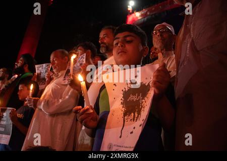 Srinagar, Jammu-et-Cachemire, Inde. 29 juillet 2024. Un garçon musulman chiite cachemiri tient une bougie et une pancarte lors d'une manifestation contre la violence sectaire visant les musulmans chiites pachtoun à Parachinar, situé dans le district de Kurram, dans la province pakistanaise de Khyber Pakhtunkhwa. Plus de 400 musulmans chiites ont été tués dans les violences sectaires chiites-sunnites qui se poursuivent à Parachinar. Les dirigeants chiites locaux affirment que les radicaux sunnites et l'armée pakistanaise ciblent et tuent la minorité chiite, les forçant à quitter le pays et à fuir en Iran. (Crédit image : © Adil Abass/ZUMA Press Wire) EDITORIAL Banque D'Images