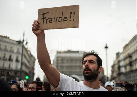 Madrid, Espagne. 29 juillet 2024. Un homme tient une pancarte indiquant « fraude » pendant une manifestation. Les Vénézuéliens résidant à Madrid se sont rassemblés à la Puerta del sol pour protester et exprimer leur désaccord avec les résultats des élections au Venezuela et apporter leur soutien à la chef de l'opposition Maria Corina Machado et au candidat de l'opposition Edmundo Gonzalez. Crédit : Marcos del Mazo/Alamy Live News Banque D'Images