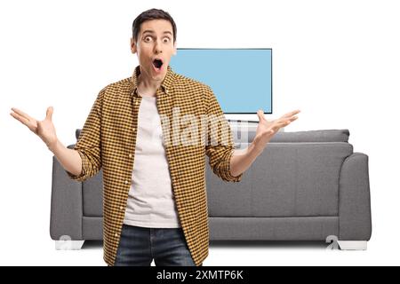 Jeune homme surpris devant une télévision isolé sur fond blanc Banque D'Images