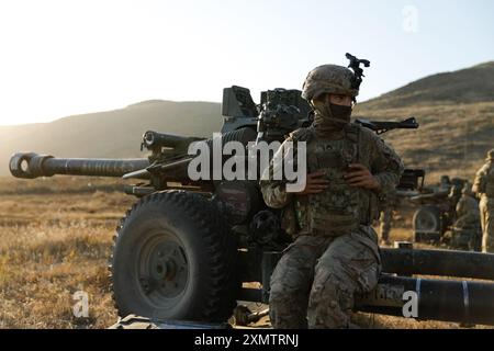 Le sergent d'état-major Alejandro Bell-Socarras, 1er bataillon, 143e régiment d'artillerie de campagne, 79e brigade d'infanterie, équipe de combat de la Garde nationale de Californie, attend des instructions lors d'un entraînement annuel à l'île de San Clemente, Calif, le 22 juillet 2024. L'obusier M119 peut être facilement remorqué par des véhicules spécialisés et rapidement déployé en cas de besoin. (Photo de la Garde nationale de l'armée américaine par le SPC William Franco Espinosa) Banque D'Images