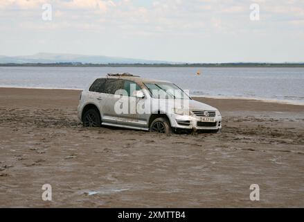 Une voiture, coincée dans le sable, sur la plage Banque D'Images