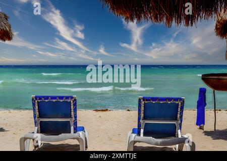 Ensemble de longues chaises vides en face de l'océan sur la plage Playa del carmen au Mexique. Banque D'Images