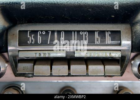 Un vieux cadran d'autoradio à bouton poussoir AM vintage en chrome monté dans un tableau de bord Banque D'Images