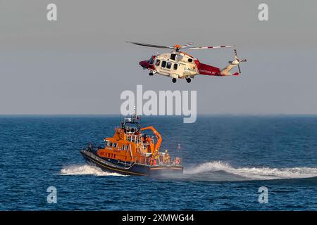 Weymouth, Dorset, Royaume-Uni. 29 juillet 2024. Le Severn Class RNLI Lifeboat RNLB Ernest and Mabel fait une exposition en soirée pour le public au large de la côte à Nothe Gardens pendant la journée de plaisir des organismes de bienfaisance pendant la semaine du bateau de sauvetage à Weymouth dans le Dorset. Un avantage supplémentaire pour les spectateurs a été l'apparition imprévue de l'hélicoptère des garde-côtes de Lee on Solent qui a treuillé un membre de l'équipage de l'hélicoptère du pont du bateau de sauvetage après qu'il a été appelé dans la région pour effectuer une fouille de la côte de Portland. Crédit photo : Graham Hunt/Alamy Live News Banque D'Images