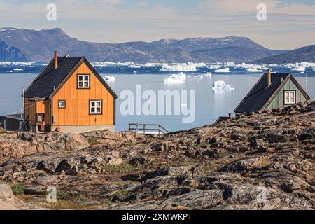 Maisons typiques groenlandaises en face des icebergs et des montagnes, ensoleillé, été, Uummannaq, Groenland Banque D'Images