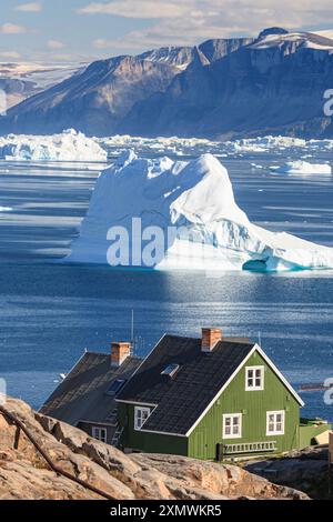 Maisons typiques groenlandaises en face des icebergs et des montagnes, ensoleillé, été, Uummannaq, Groenland Banque D'Images