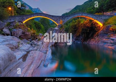 Un lever de soleil d'été au pont illuminé Ponte dei Salti. Le pont (aussi appelé 'Ponte Romano') enjambe la rivière Verzasca à Lavertezzo et est un Tie Banque D'Images