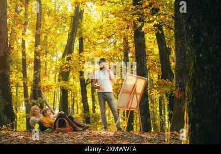 Peinture dans la nature. Démarrer une nouvelle photo. Capturez l'instant. Beauté de la nature. Homme barbu femme et fils relaxent la nature automnale. Dessiner de la vie. Peintre Banque D'Images