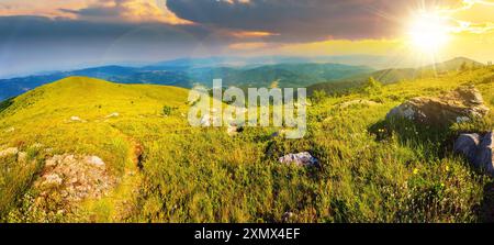 paysage panoramique avec chemin étroit à travers une prairie herbeuse parmi les pierres blanches au sommet de la chaîne de montagnes au coucher du soleil. beau paysage de campagne à eve Banque D'Images