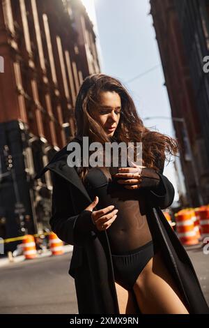 Silhouettée contre les bâtiments de New York, une jeune femme danse dans la rue. Banque D'Images