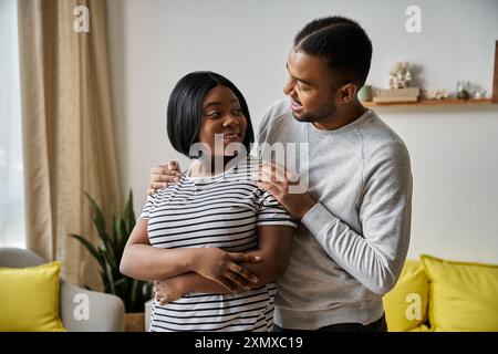 Un couple afro-américain aimant partage un moment d'intimité à la maison. Banque D'Images