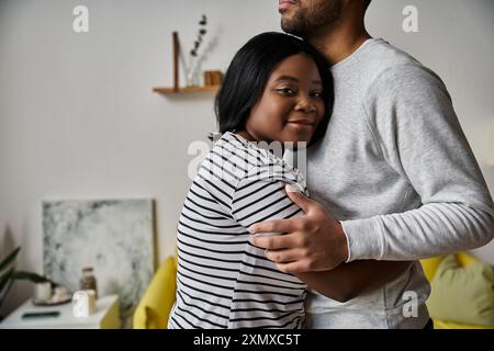 Un couple s'embrasse dans leur maison, exprimant leur affection l'un pour l'autre. Banque D'Images