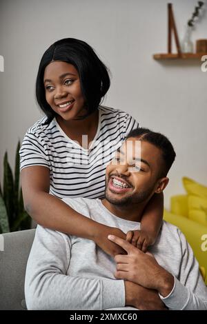 Un couple heureux s'embrasse dans leur maison, profitant d'un moment de convivialité. Banque D'Images