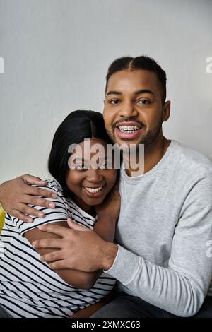 Un couple afro-américain s'embrasse, souriant chaleureusement à la caméra. Banque D'Images