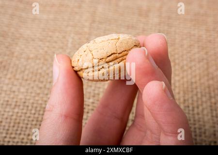 Amande turc cookie dans la main sur une toile de lin Banque D'Images