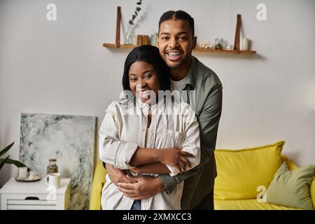 Un heureux couple afro-américain embrasse dans leur maison, montrant leur amour et leur connexion. Banque D'Images