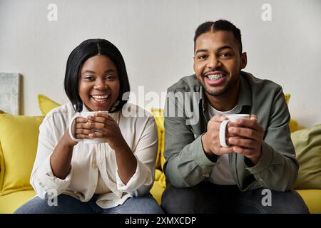 Un couple afro-américain aimant profite d'une boisson chaude ensemble à la maison. Banque D'Images