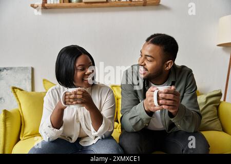 Un couple afro-américain aimant profite d'une date de café confortable à la maison. Banque D'Images