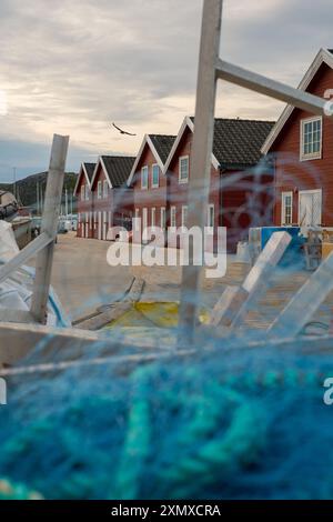 Pêche, maisons et bateau dans le port pour voyage, voyage et affaires en village ou petite ville. Bâtiments, ciel ou nuages et gros plan de filet pour l'industrie Banque D'Images