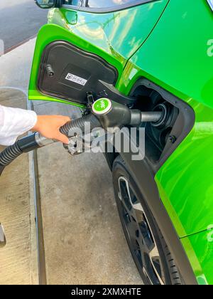 Vue rapprochée du ravitaillement d'une voiture verte en voyage d'été. Banque D'Images