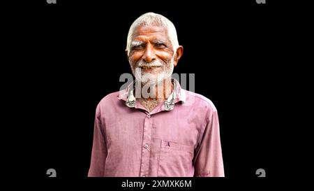 Heureux vieil Indien âgé. Portrait d'un fermier indien rural posant sur fond noir. Banque D'Images