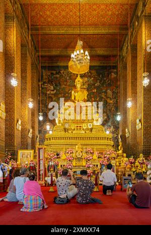 Les adorateurs oin devant la statue de Phra Bouddha dans le hall d'ordination Phra Ubosot, complexe Wat Pho, Bangkok, Thaïlande Banque D'Images