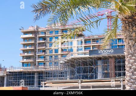 Abu Dhabi, Émirats arabes Unis - 26 juin 2024 : grue à tour travaillant sur le site de construction d'un nouveau bâtiment résidentiel dans le quartier culturel, île de Saadiyat Banque D'Images