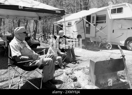 Couple caucasien, âgé de 60 à 65 ans, et une jeune fille, âgée de 3 à 5 ans, profitant d’une journée de détente en camping dans un pittoresque terrain de camping à Brevard, Caroline du Nord. Banque D'Images