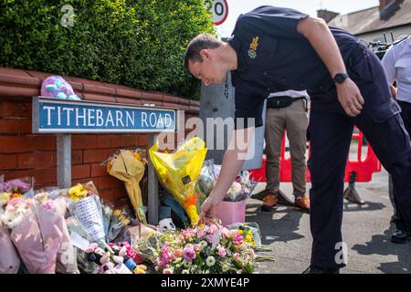 Des membres du Merseyside Fire and Rescue Service déposent des fleurs et un hommage près de la scène à Hart Street, Southport, où trois enfants sont morts et huit ont été blessés dans une attaque au couteau «féroce» lors d'un événement Taylor Swift dans une école de danse lundi. Un homme de 17 ans de Banks, dans le Lancashire, a été arrêté pour meurtre et tentative de meurtre à la suite de l'incident. Date de la photo : mardi 30 juillet 2024. Banque D'Images